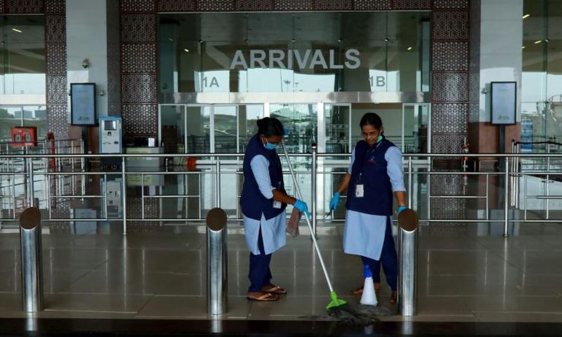Staff clean the arrivals terminal at Cochin International Airport in Kochi ahead of the arrival of a first repatriation flight carrying Indian citizens from the Gulf