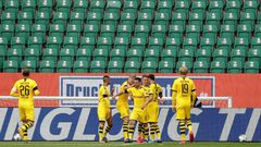 Raphael Guerreiro (C) celebrates scoring the opening goal in Borussia Dortmund's 2-0 win at Wolfsburg in a near-empty stadium.