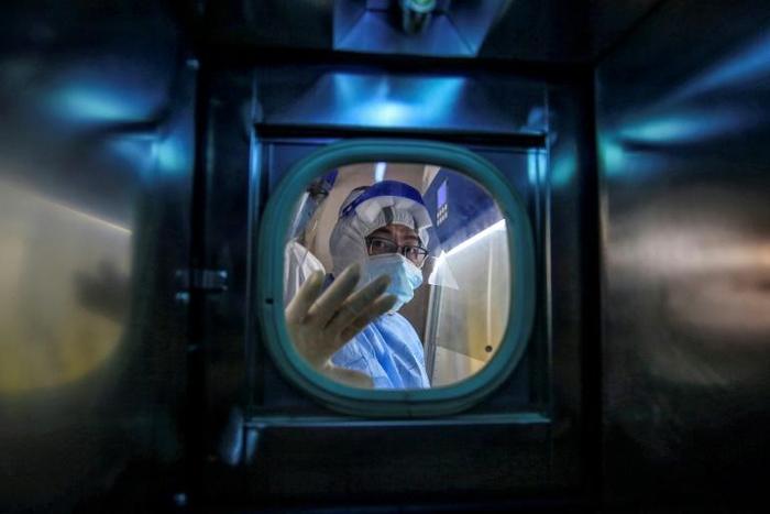 Medical staff look out of an isolation ward at the Red Cross Hospital in Wuhan in China