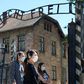As the site reopens following Coronavirus lockdown, visitors to Auschwitz contemplate the  entrance gate with its inscription "Work sets you free"
