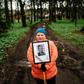 A woman carries a portrait of her grandfather near a monument in a small village outside Moscow dedicated to those who fought in World War II