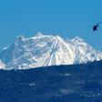 A helicopter carrying a rescue team flies in front of the Annapurna mountain range, in Pokhara, west of Kathmandu, during the initial search in January