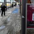 Commuters walk past a sign warning about the COVID-19 at San Ysidro port of entry, in Tijuana, Baja California state, Mexico