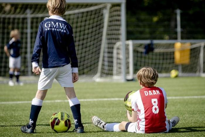 Dutch children play football during the first reopening day of youth training camps in the Netherlands after the coronavirus covid-19 outbreak in The Hague, on April 29, 2020