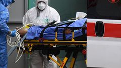 Medical workers stretch a patient from an Italian Red Cross ambulance into an intensive care unit set up in a sports center outside the San Raffaele hospital in Milan, on March 23, 2020 during the COVID-19 new coronavirus pandemic. (Photo by Miguel MED...