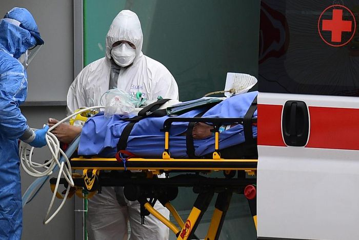 Medical workers stretch a patient from an Italian Red Cross ambulance into an intensive care unit set up in a sports center outside the San Raffaele hospital in Milan, on March 23, 2020 during the COVID-19 new coronavirus pandemic. (Photo by Miguel MED...