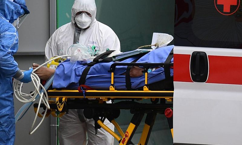 Medical workers stretch a patient from an Italian Red Cross ambulance into an intensive care unit set up in a sports center outside the San Raffaele hospital in Milan, on March 23, 2020 during the COVID-19 new coronavirus pandemic. (Photo by Miguel MED...