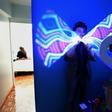 Magician Gustavo Pintos shakes a light-stick as he performs for an online birthday party hundreds of kilometers away from his home in Buenos Aires