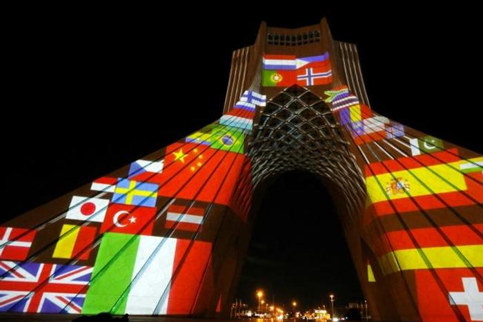 Tehran's Azadi (Freedom) Tower is lit up with national flags in solidarity with countries affected by the COVID-19 pandemic