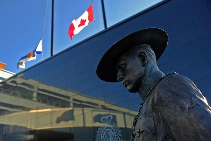 Flags of Nova Scotia and Canada fly at half-staff outside the Nova Scotia Royal Canadian Mounted Police (RCMP) headquarters in Dartmouth on April 19, 2020, after a shooting rampage left at 22 dead
