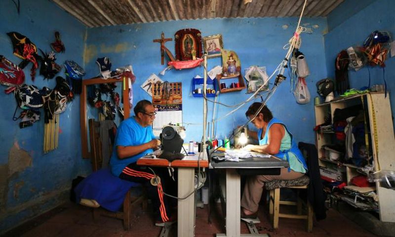 Jose Isaias Huerta (L), a former wrestler, and his wife, Virginia, manufacture lucha libre masks which people are using as face masks in the fight against coronavirus