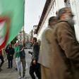 An Algerian protester waves the national flag during a weekly anti-government demonstration in the capital Algiers on March 13 before the rallies were suspended because of the novel coronavirus