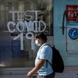A man walks past a pharmacy where COVID-19 tests are conducted in  Santiago, Chile