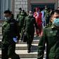 Military officers who are also members of parliament wear facemasks against the coronavirus as they leave the national assembly