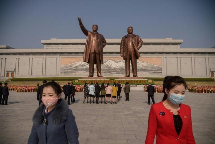 Pyongyang residents pay their respects at the giant bronze statues of Kim Il Sung and his son and successor Kim Jong Il