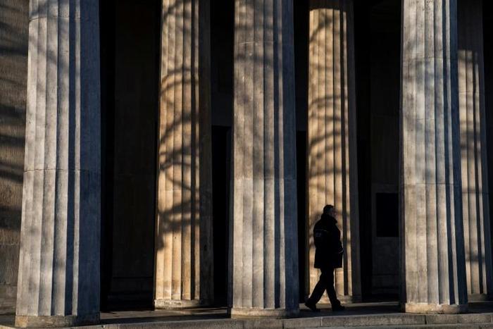 A guard walks past the columns of a memorial in Berlin that will figure in VE day ceremonies