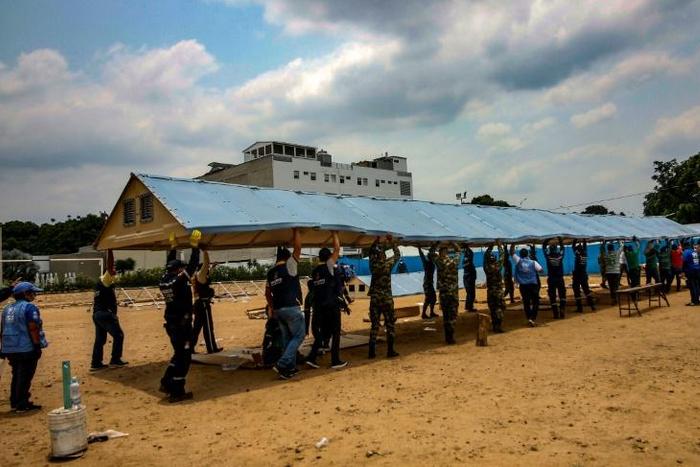 Firefighters, soldiers and workers from the office of the United Nations High Commissioner for Refugees (UNHCR)setting up a field hospital for coronavirus cases on the border with Venezuela, on March 28, 2020