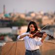 Fadia Khalil, a 22-year-old member of  the Iraqi National Symphony Orchestra, plays violin on the roof of her house in Baghdad