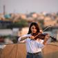 Fadia Khalil, a 22-year-old member of  the Iraqi National Symphony Orchestra, plays violin on the roof of her house in Baghdad