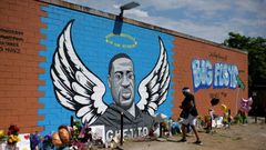 Visitors pay their respects to George Floyd in front of a mural in Houston, Texas on Monday, June 8, 2020