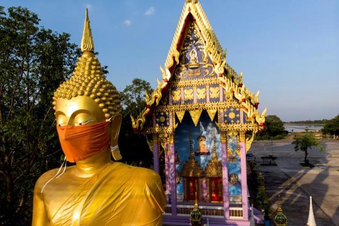 A face mask was placed on the face of a giant Buddha statue outside Bangkok