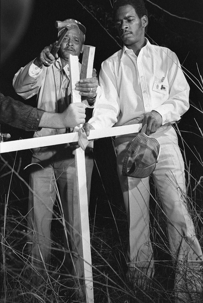 Two members of the United Youth Adult Conference hammer a cross into the ground, marking the place where Aaron Wyches body was found on June 24, 1980.
