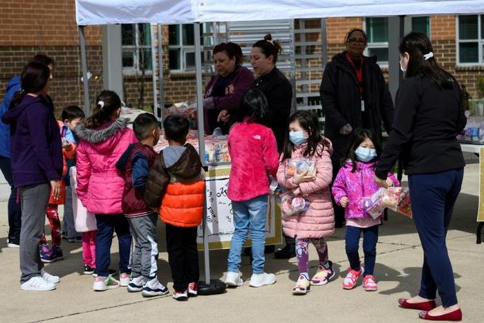 Children pick up free lunch in Arlington, Virginia on March 16, 2020, after schools closed due to coronavirus. Disrupted school lunch programs could be a factor in alarming rises in hunger among US children since the outbreak began, the study says
