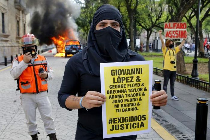 The arrests followed riots in Guadalajara after protesters had gathered to demand justice over Giovanni Lopez's death; a
demonstrator holds a banner during a protest in Guadlalajara, Jalisco