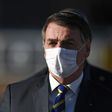 In this file photo taken on May 12, 2020 Brazilian President Jair Bolsonaro wears a face mask as he arrives at a flag-raising ceremony at the Alvorada Palace in Brasilia