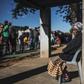 Informal traders and waste-pickers queue for food at a Soweto parking lot