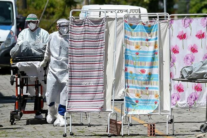 Healthcare workers in protective clothing transport the body of a COVID-19 victim outside Joao Lucio Hospital in Manaus, Brazil, on April 21, 2020