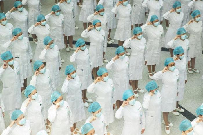 Nurses recite an oath on International Nurses Day at Tongji Hospital in Wuhan, China, where authorities have ordered the entire population be tested for the coronavirus