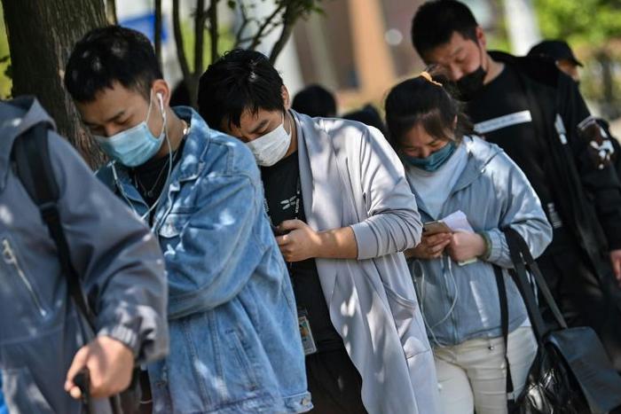 Workers wait in line to collect salaries in Shanghai