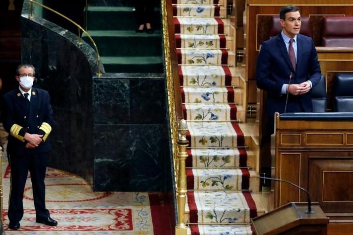 Spanish Prime Minister Pedro Sanchez speaks from his seat during a session to debate the extension of a national lockdown to curb the spread of the novel coronavirus at the Lower Chamber of the Spanish parliament in Madrid