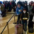 Ukrainian seasonal workers wait in line to check in for a flight to Finland where they can earn much more than at home as the coronavirus pandemic ravages the economy