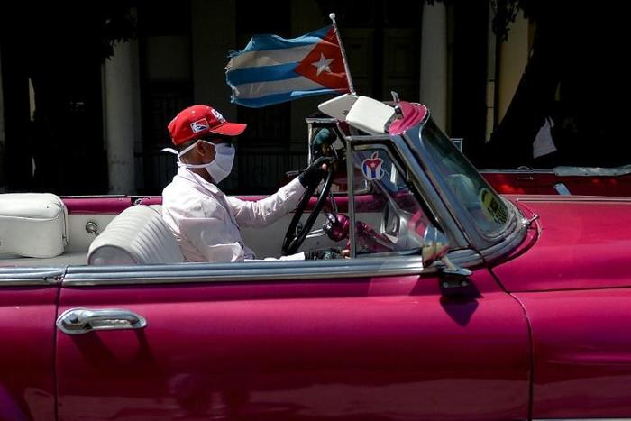 The driver of a vintage American car wears a face mask while taking tourists around Havana -- but Cuba is to close to visitors over the coronavirus outbreak