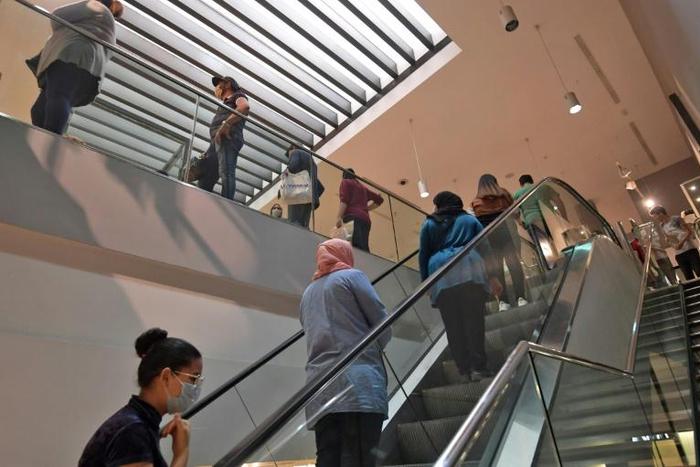 Shoppers wearing protective face masks  observe a safe distance at a clothing store in the Tunisian capital on May 12, 2020 following the easing of the lockdown measures put in place to combat the spread of coronavirus
