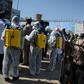 An Afghan policeman gestures as volunteers wearing a hazmat suits and a facemasks gather before the start of a preventive campaign against the spread of the COVID-19 coronavirus, in Kabul on March 18, 2020