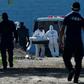 Forensic experts take away a corpse from the women's prison in Tamara, Honduras following the murder of six inmates