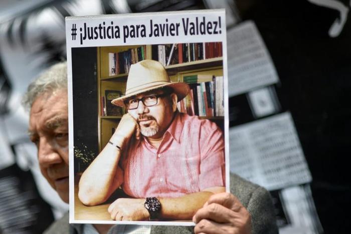 A demonstrator holds a picture of slain Mexican journalist Javier Valdez during a protest in Mexico City on May 16, 2017