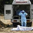 A Muslim man in protective gear offers funeral prayers for a policeman who died from COVID-19 at a graveyard in New Delhi