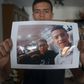 Anass Tahiri, 22, holds a picture of him and his brother, Iliass, who died while being restrained in a juvenile detention centre in Spain