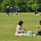 Two women enjoy a drink in the grass in London's Hyde Park, opened for the first time in months