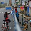 Barriers to stop the spread of the coronavirus in Wuhan have divided communities
