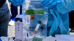 A health worker stores coronavirus test samples at a drive-through clinic in West Palm Beach, Florida