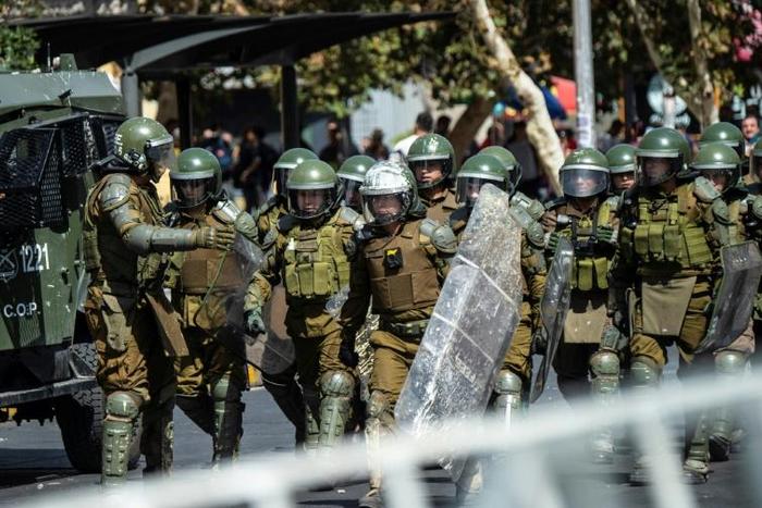 Chilean riot police take position during a protest against President Sebastian Pinera on the second anniversary of his inuguration in Santiago on March 11, 2020.