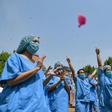 Petals fell on to the upturned faces of medical personnel clad in protective gear