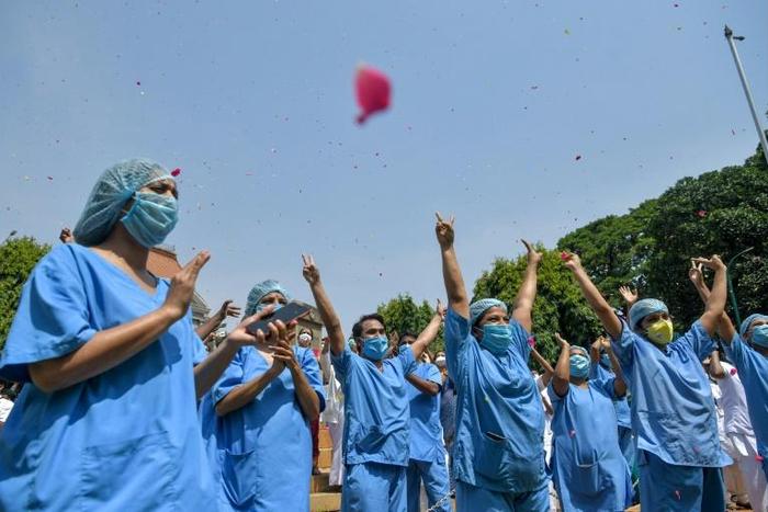 Petals fell on to the upturned faces of medical personnel clad in protective gear