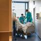 A Swiss soldier (R) helps to move the bed of a COVID-19 patient, at the Pourtales Hospital in Neuchatel on March 25, 2020, after Switzerland deployed its army reservists to relieve hospitals under pressure from the outbreak of COVID-19