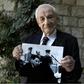 Bach, pictured holding a photograph showing himself (below) during the Eichmann trial, said, 'Not a day passes without me remembering some particular item, or some particular piece of evidence, or some particular moment from the Eichmann trial'